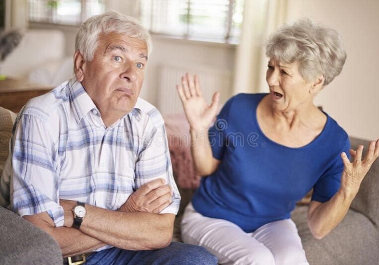 A woman and an older man are sitting on the couch