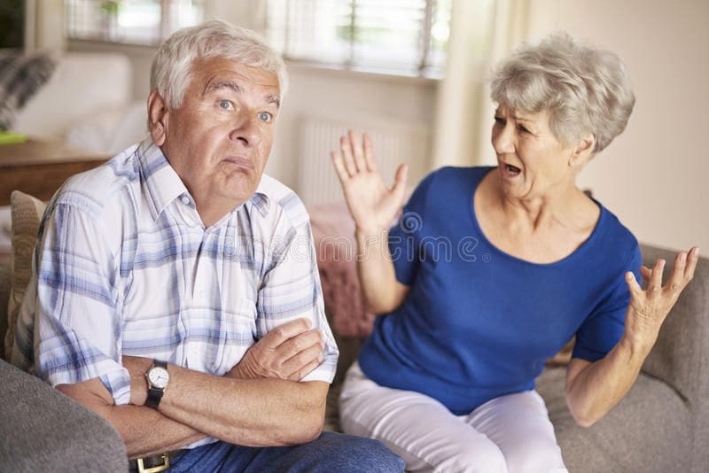 A woman and an older man are sitting on the couch