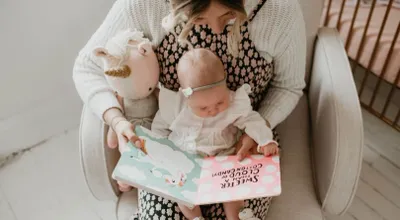 A woman is reading to her baby